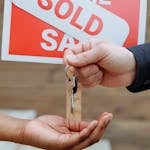 Home 11 Person Handing Out Keys to Another Person